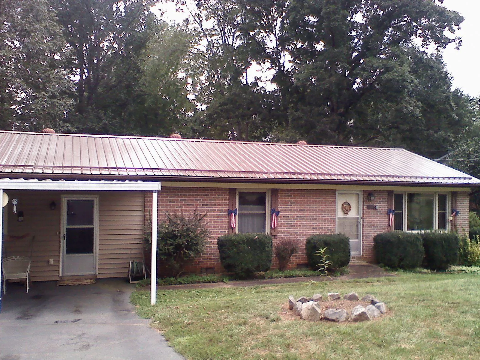 Bronze metal roof and carport on a brick ranch home — Roof Repair work by our crew in Montvale